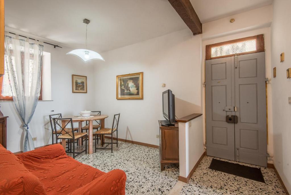 Cette chambre comprend un lit, une table et une porte. dans l'établissement Lo Zio Ezio, à Montepulciano