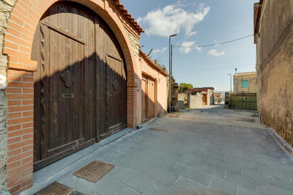 un callejón con una gran puerta de madera en un edificio de ladrillo en Casa Campidanese, en Mògoro