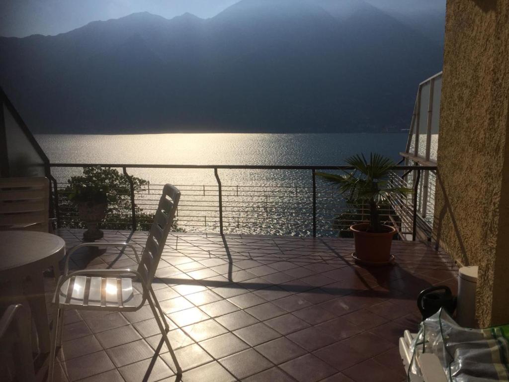 Pino Lago Maggiore的住宿－Lago Maggiore- Casa Roccia-Ferienwohnung in Pino sulla Sponda，阳台配有两把椅子,享有水景