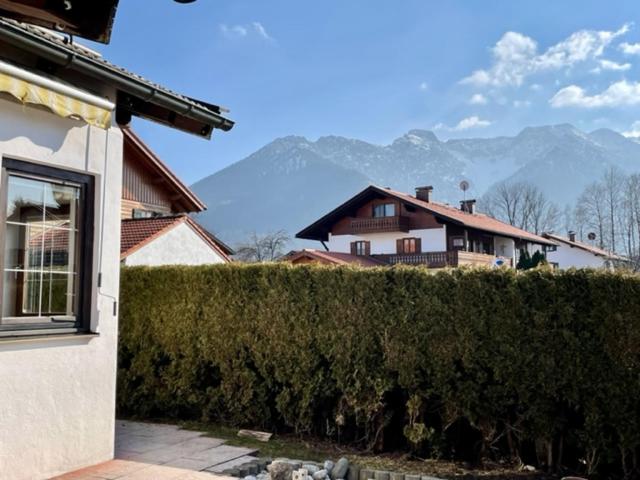 a house with a hedge in front of a house at Kleines Häuschen mit Bergblick in Eschenlohe