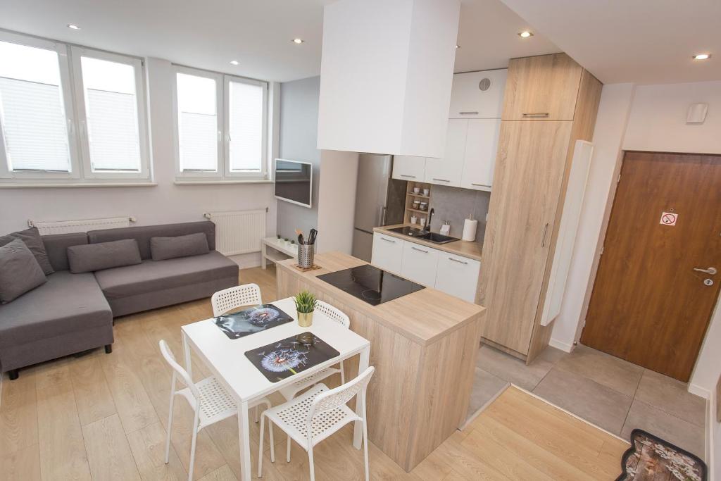 a kitchen and living room with a couch and a table at Urban Jungle Apartment in the city center in Białystok