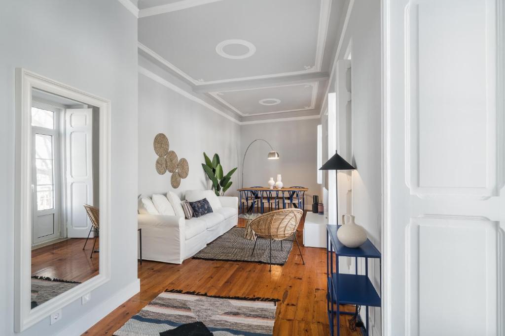 uma sala de estar com um sofá branco e uma mesa em Casa Boma Lisboa - Elegant and Charming Apartment - Alcantara V em Lisboa