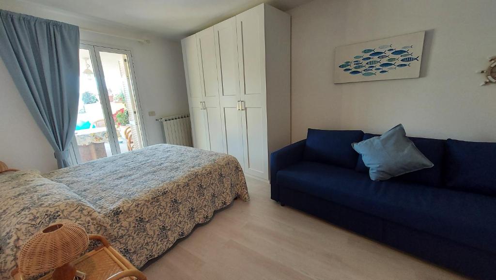 een slaapkamer met een bed en een blauwe bank bij Villa Jone in Diano Marina