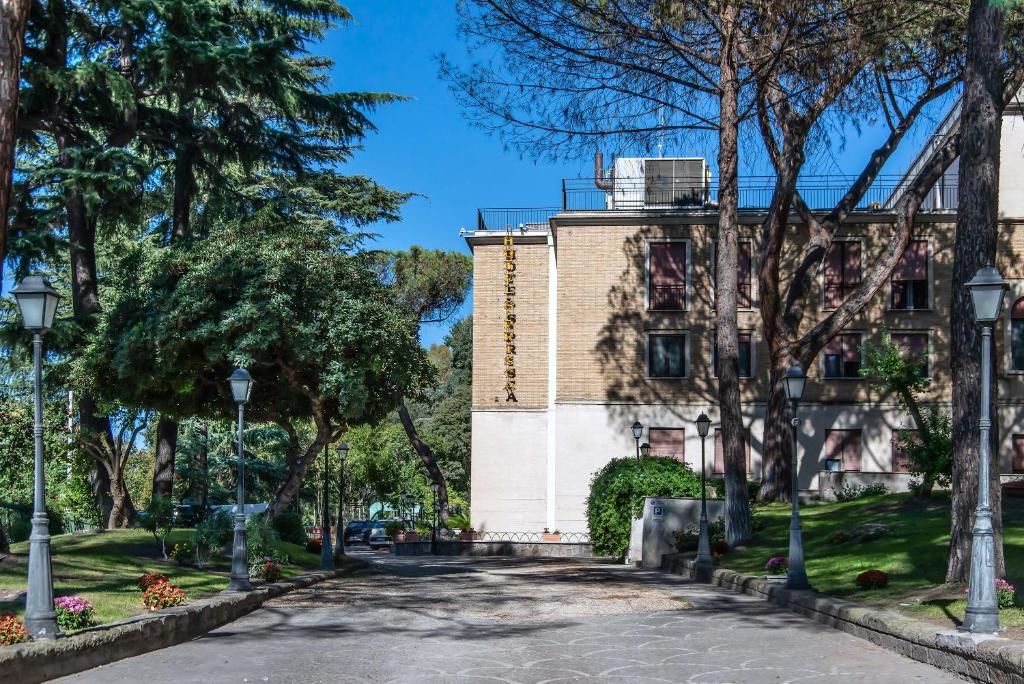 una strada di fronte a un edificio alberato di Hotel Santa Prisca a Roma