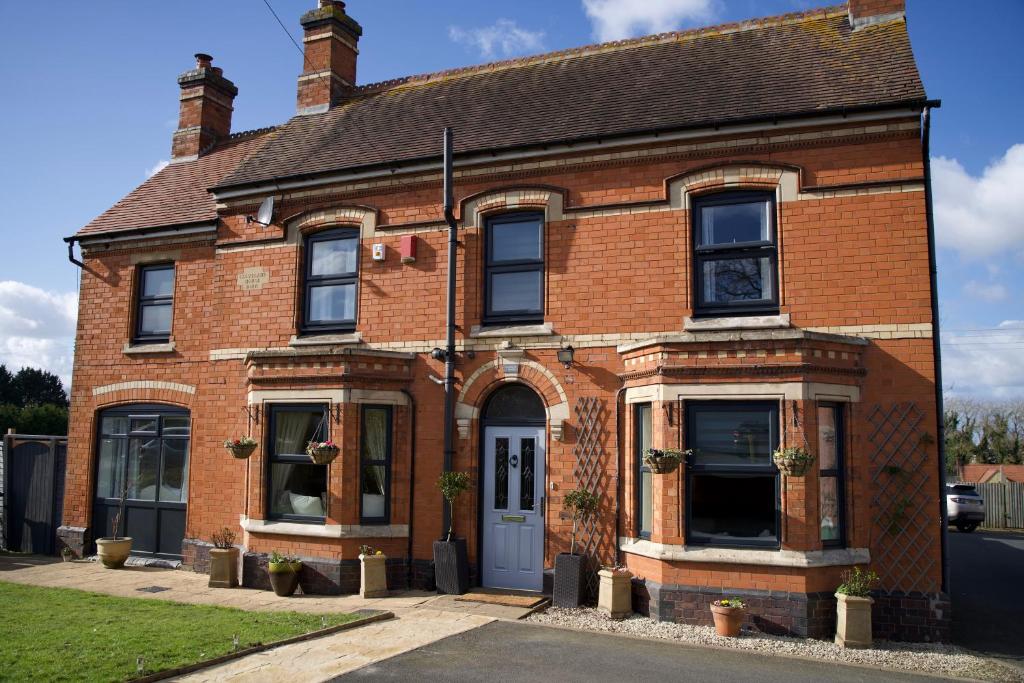 a red brick house with a white door at Stunning 5 Bedroom Victorian home with optional hot tub in Pershore
