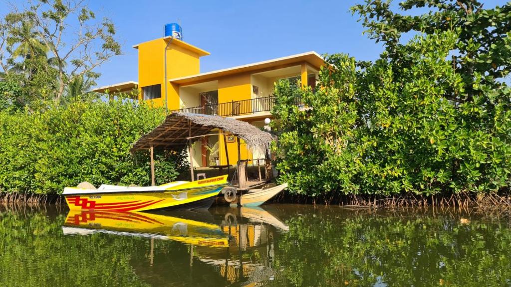 Nature Paradise Guesthouse في فايكال: قارب في الماء امام المنزل
