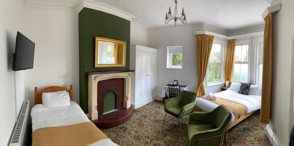 um quarto de hotel com duas camas e uma lareira em The Cedars Ashby em Ashby de la Zouch