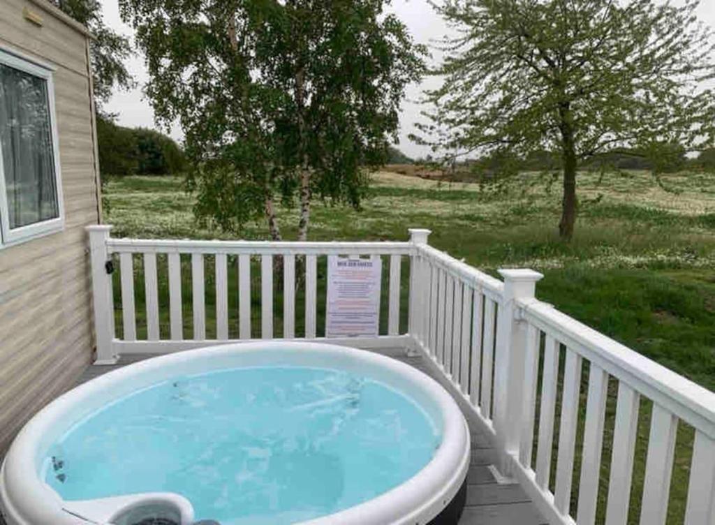 a jacuzzi tub on the deck of a house at Lovely 3-Bed Caravan with Hot Tub in Lincolnshire in Lincoln