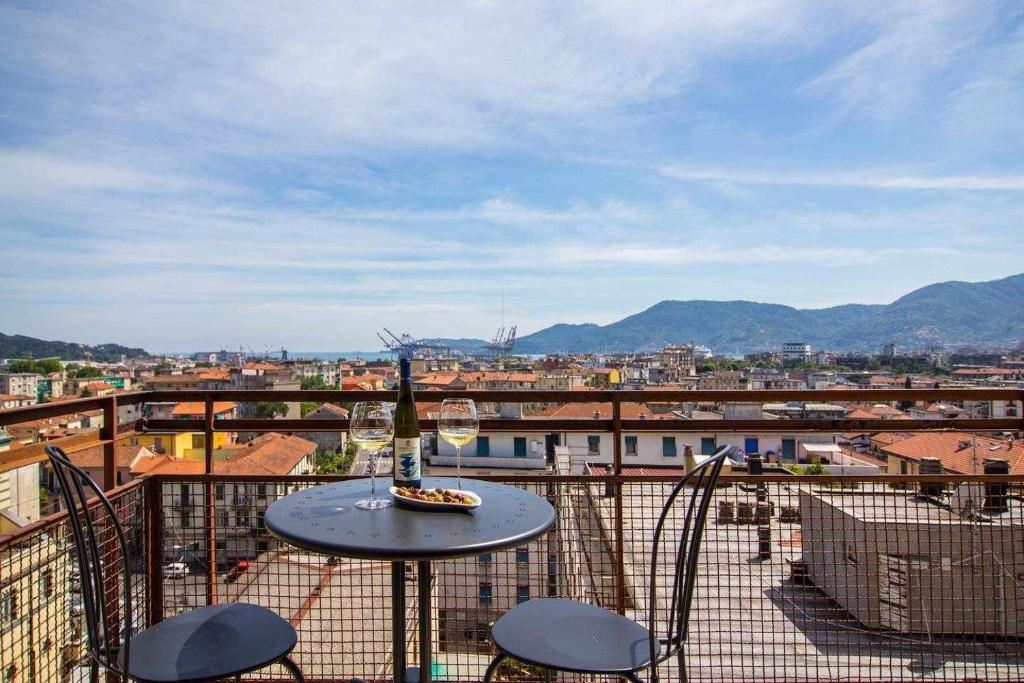 uma vista para a cidade a partir de uma varanda com uma mesa e cadeiras em Residenza Franca Vista panoramica em La Spezia