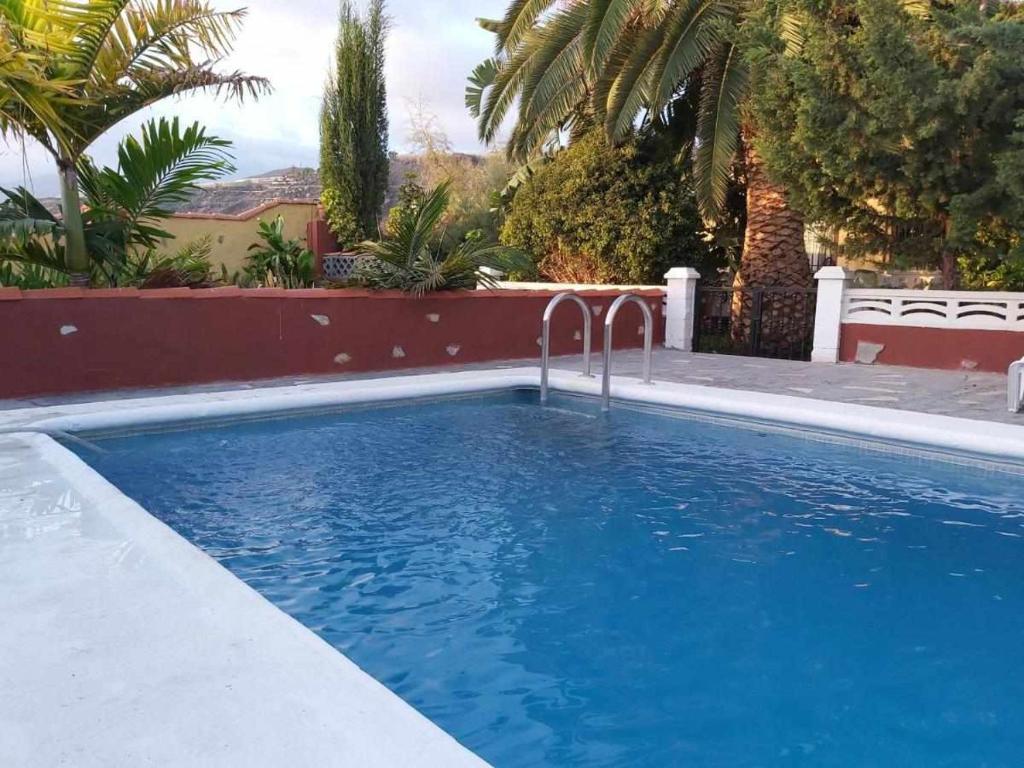 een zwembad met blauw water in een tuin bij Villa Rural Casa Jorsam UNIFAMILIAR in Tazacorte