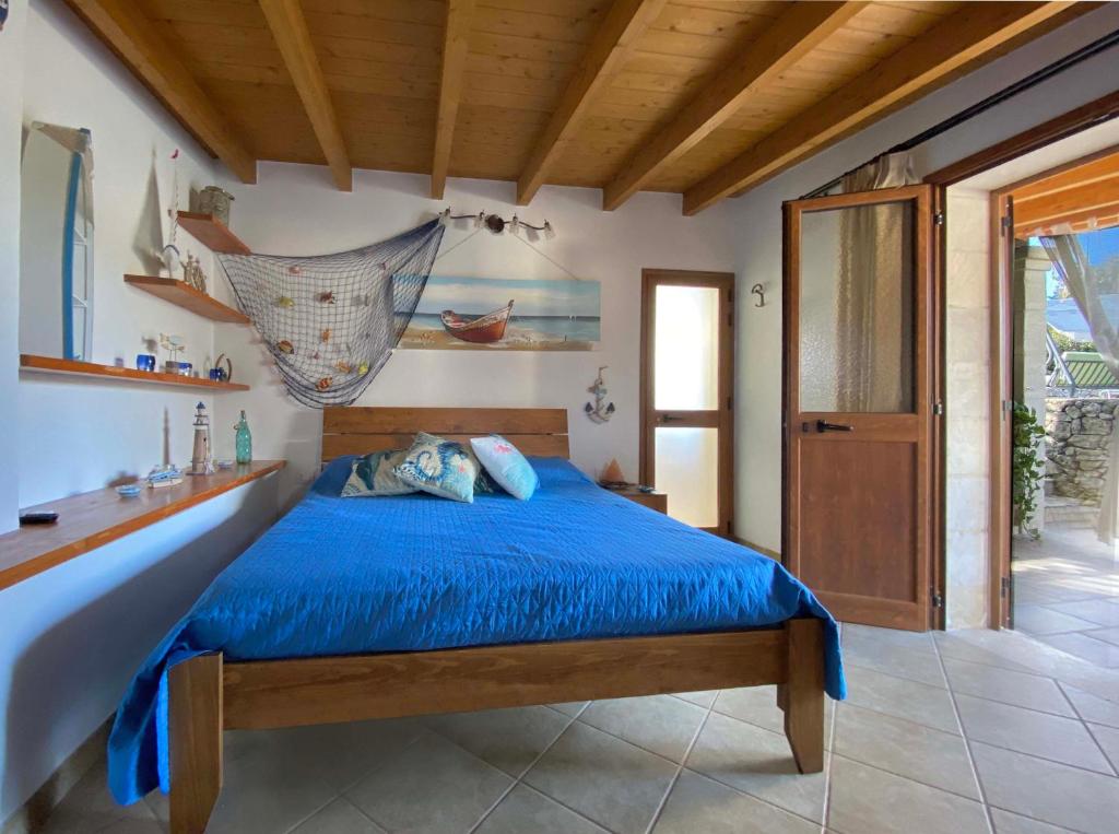 sypialnia z łóżkiem z niebieską kołdrą w obiekcie Villa Nicrys by Perle di Puglia w mieście Maglie