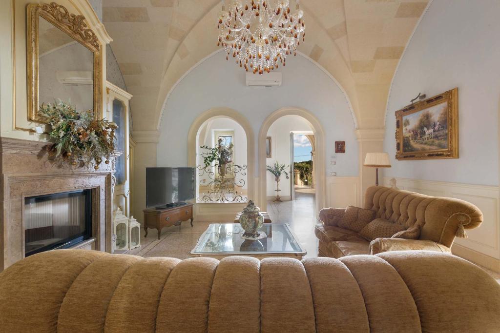 salon z kanapą i kominkiem w obiekcie Villa Nicrys by Perle di Puglia w mieście Maglie