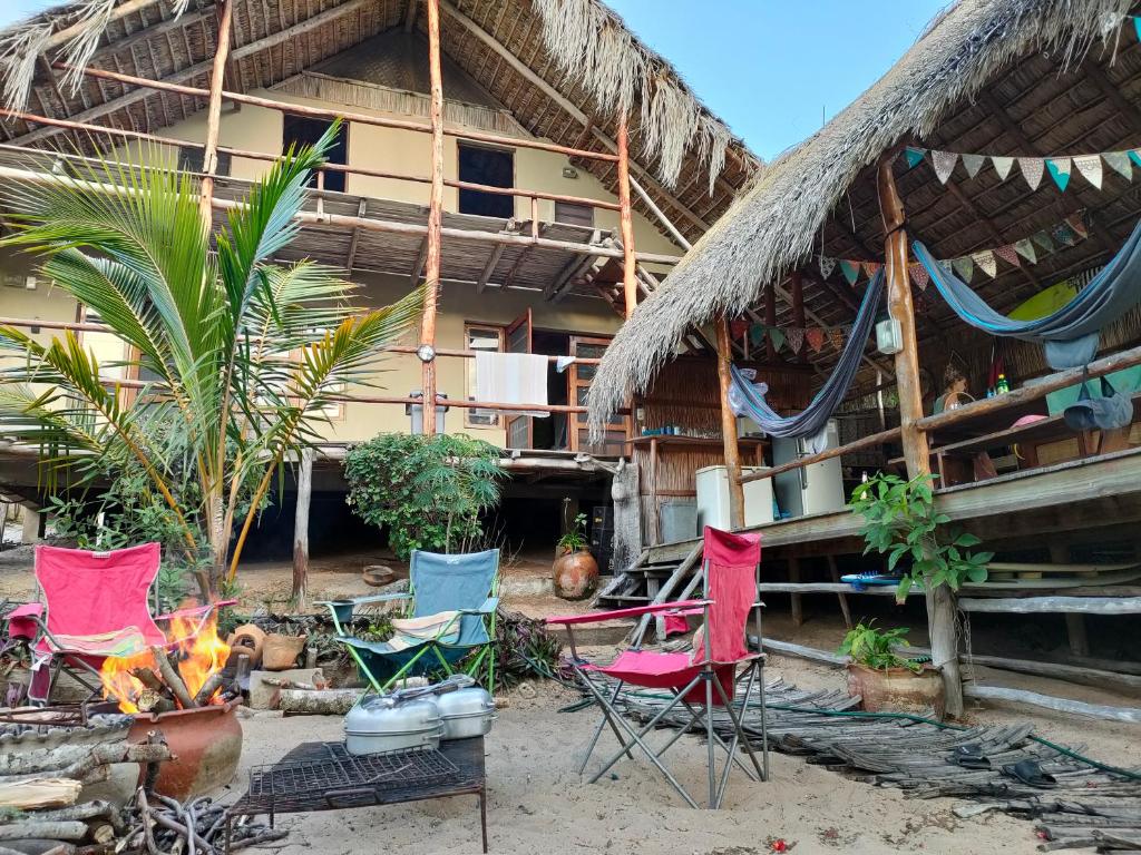 a group of chairs and a fire in front of a building at Casa Surf Lodge - Tofo in Praia do Tofo