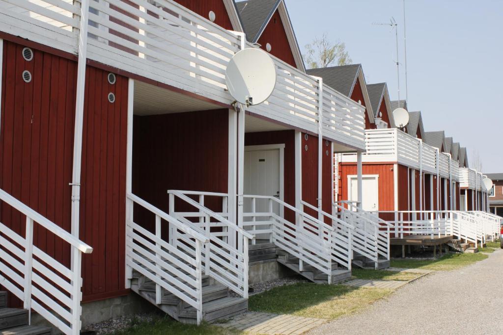 a row of red buildings with white stairs on them at Saimaa Seasons Marina Villas in Imatra