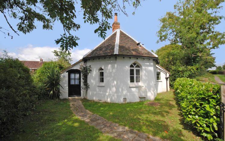 une petite maison blanche avec un toit dans l'établissement Truffle Cottage, Chichester, à Chichester