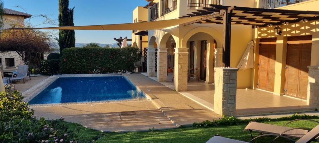 una piscina in un cortile accanto a una casa di Aphrodite Hills a Kouklia