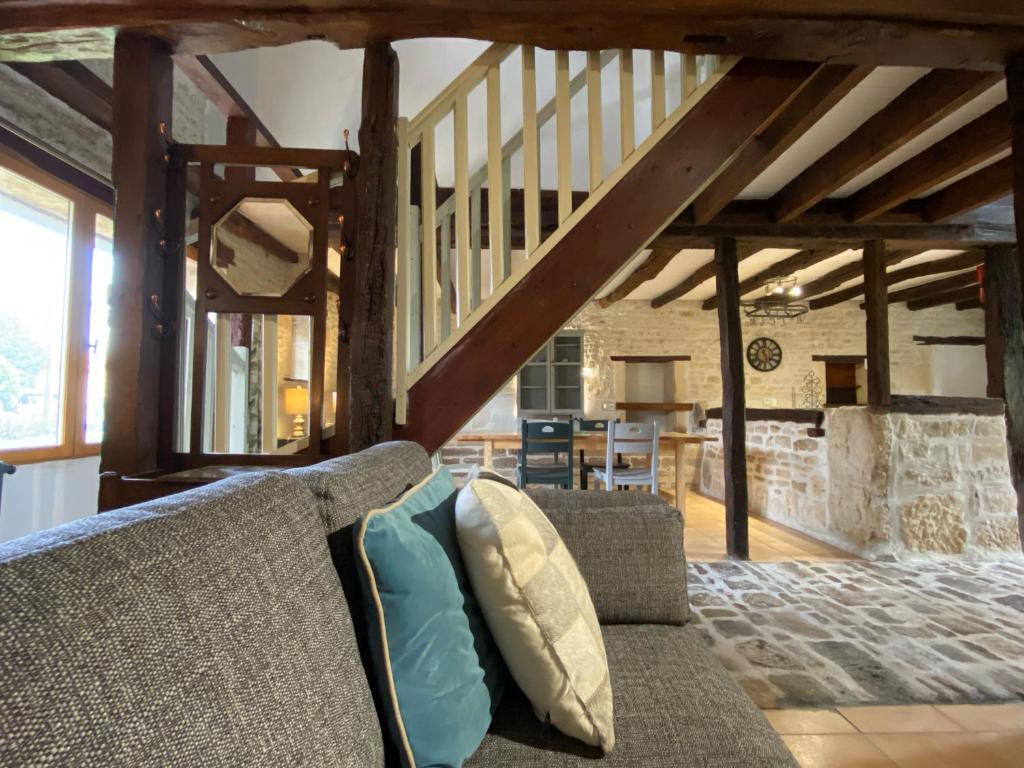 a living room with a couch and a staircase at Le Figuier - 4 bedroom Farmhouse Gite in Limalonges