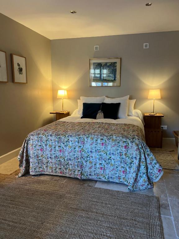 a bedroom with a large bed with two lamps at Maison Marie in Lagarde