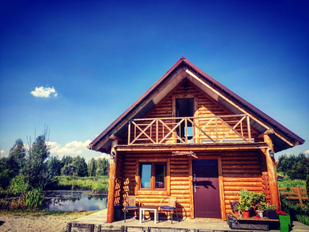 a log cabin with a porch and a table at Nad Rozlewiskiem Rzeszów in Rzeszów