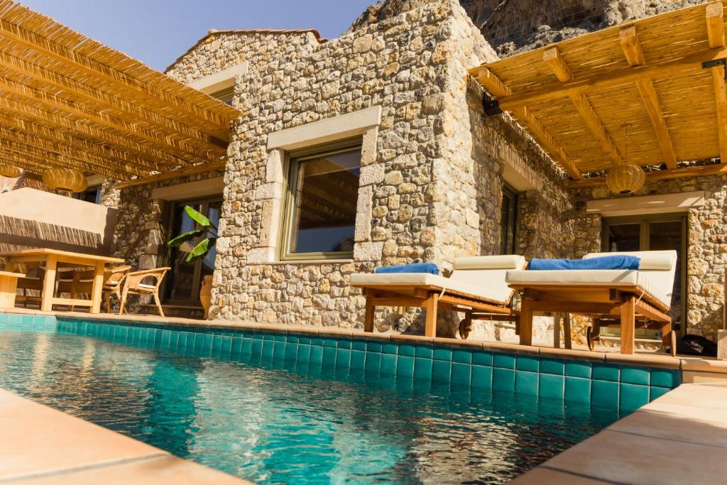 a villa with a swimming pool and a house at Petra Boutique Villas in Aryinónda