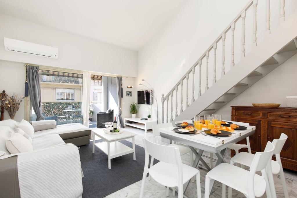 Il comprend un salon doté d'un mobilier blanc et d'un escalier. dans l'établissement Nomad YourHostHelper, à Cannes