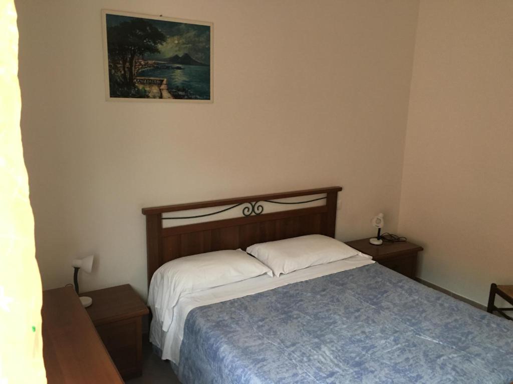 um quarto com uma cama e uma fotografia na parede em Appartamento MIRAMARE em Ventimiglia