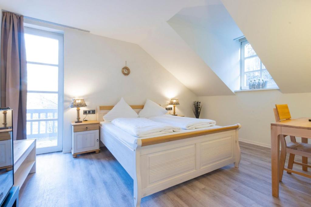 ein Schlafzimmer mit einem großen weißen Bett und einem Fenster in der Unterkunft Hotel Blechhammer in Kaiserslautern
