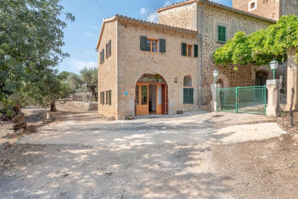 ein großes Backsteingebäude mit einem Tor davor in der Unterkunft Deià semi-detached sunny country house, near GR221 in Deià