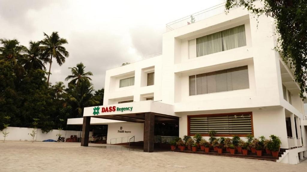 a white building with a risk agency sign in front of it at DASS REGENCY in Trichūr