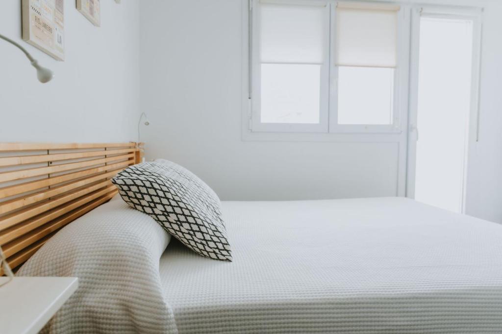 Schlafzimmer mit einem Bett mit einem Kissen und einem Fenster in der Unterkunft Apartamentos ZHR 2 in Zahara de los Atunes