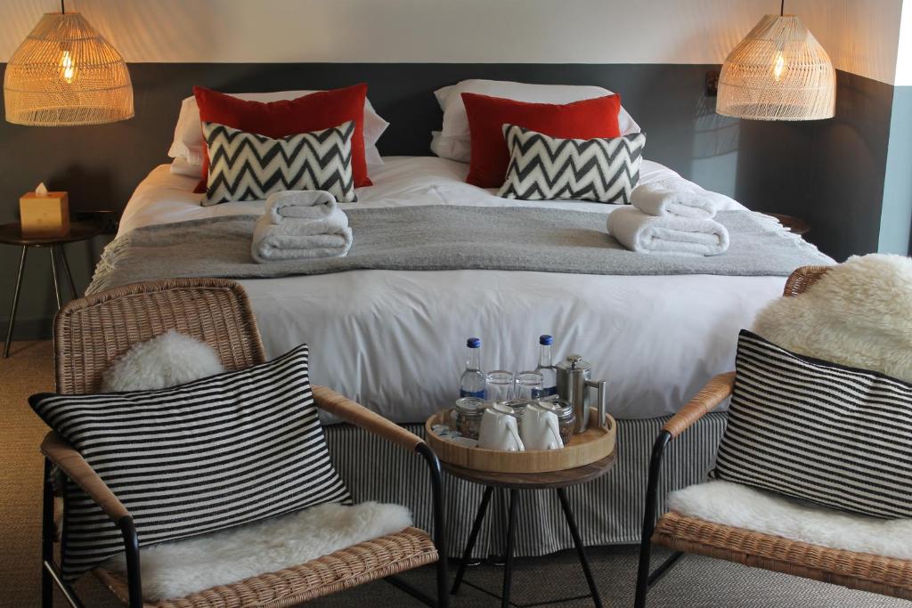 een slaapkamer met een groot bed en 2 stoelen bij The Boat Inn in Aboyne