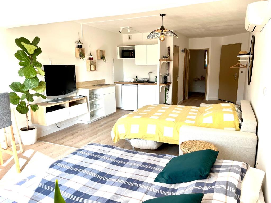 a living room with two beds and a kitchen at Le sud plage et piscine in Gassin