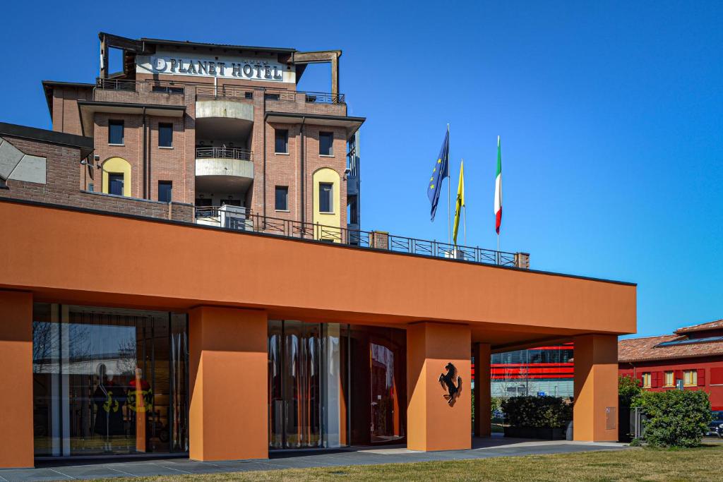 un edificio con un cartel en la parte superior en Planet Hotel, en Maranello