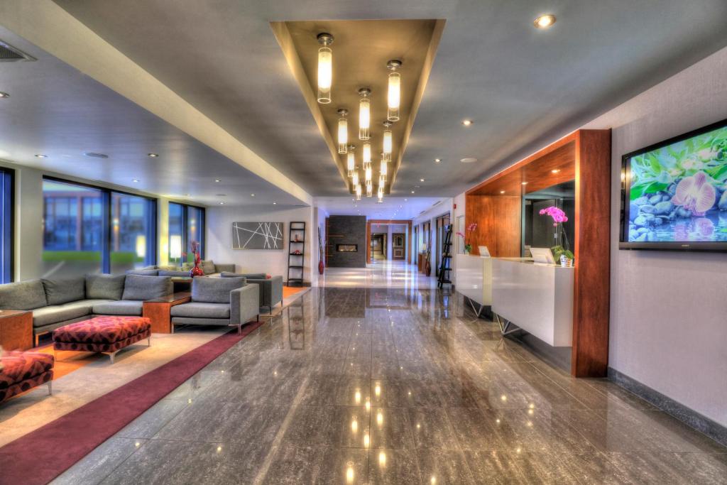 a lobby of a hotel with couches and a tv at Hotel Forestel in Val-dʼOr