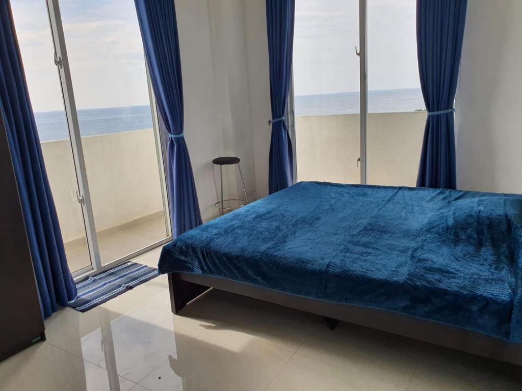 een slaapkamer met een blauw bed en grote ramen bij New 2 bedroom apartment, 100m away from the beach in Dehiwala