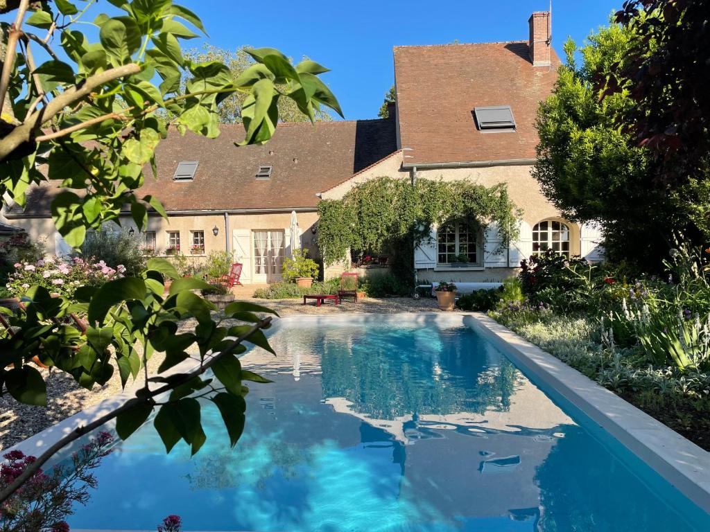 a swimming pool in front of a house at Fleurs de Vignes Piscine in Montagny-lès-Beaune