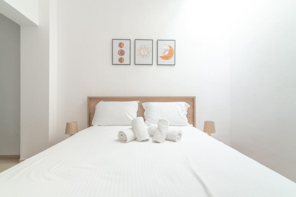 een wit bed met twee knuffels erop bij 1 BedRoom Apartment Opposite Medical Center in Heraklion