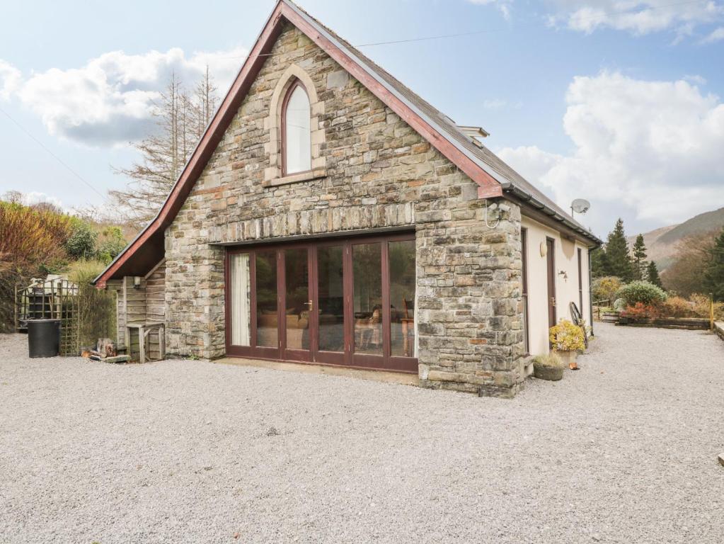 um grande edifício de pedra com uma grande janela em The Lodge em Merthyr Tydfil