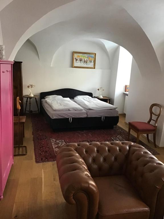 a bedroom with a bed and a leather couch at Wienerstrasse 3 in Gumpoldskirchen