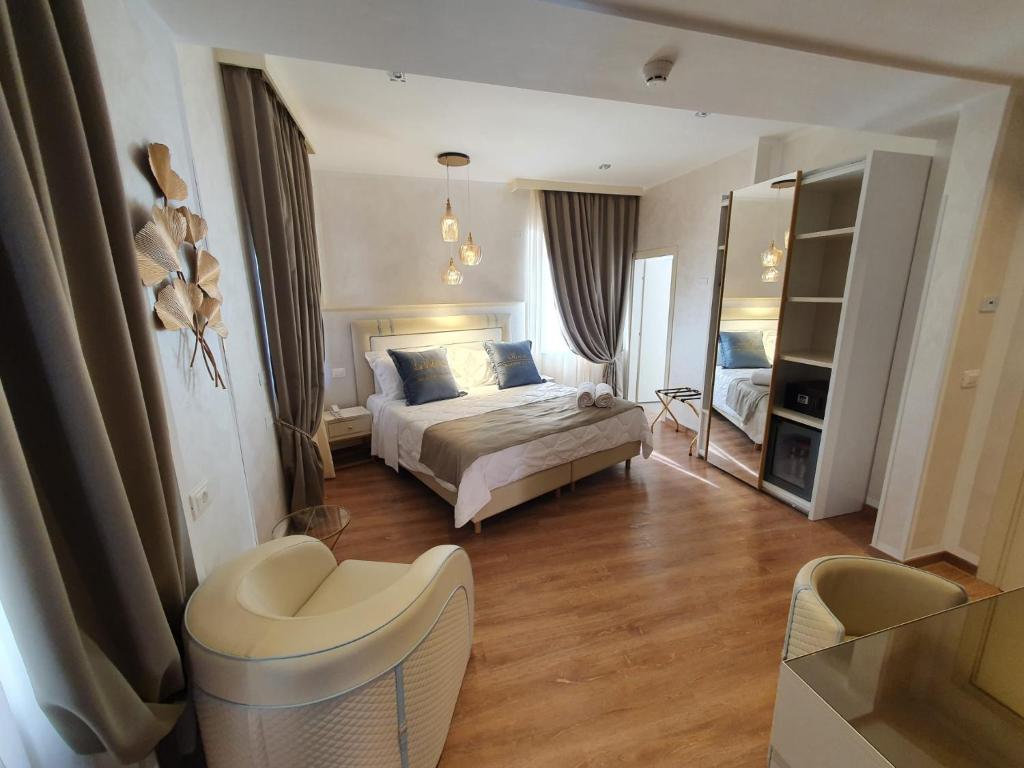 een slaapkamer met een bed en een stoel erin bij Amsterdam Suite Hotel & SPA in Rimini
