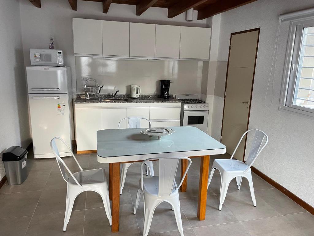 a kitchen with a table and chairs and a refrigerator at Valle de Uco. Departamento 2 habitaciones 4 huéspedes. in Tunuyán