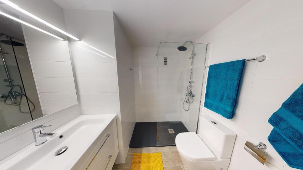 a white bathroom with a sink and a toilet at Apartamentos Eldorado in Lloret de Mar