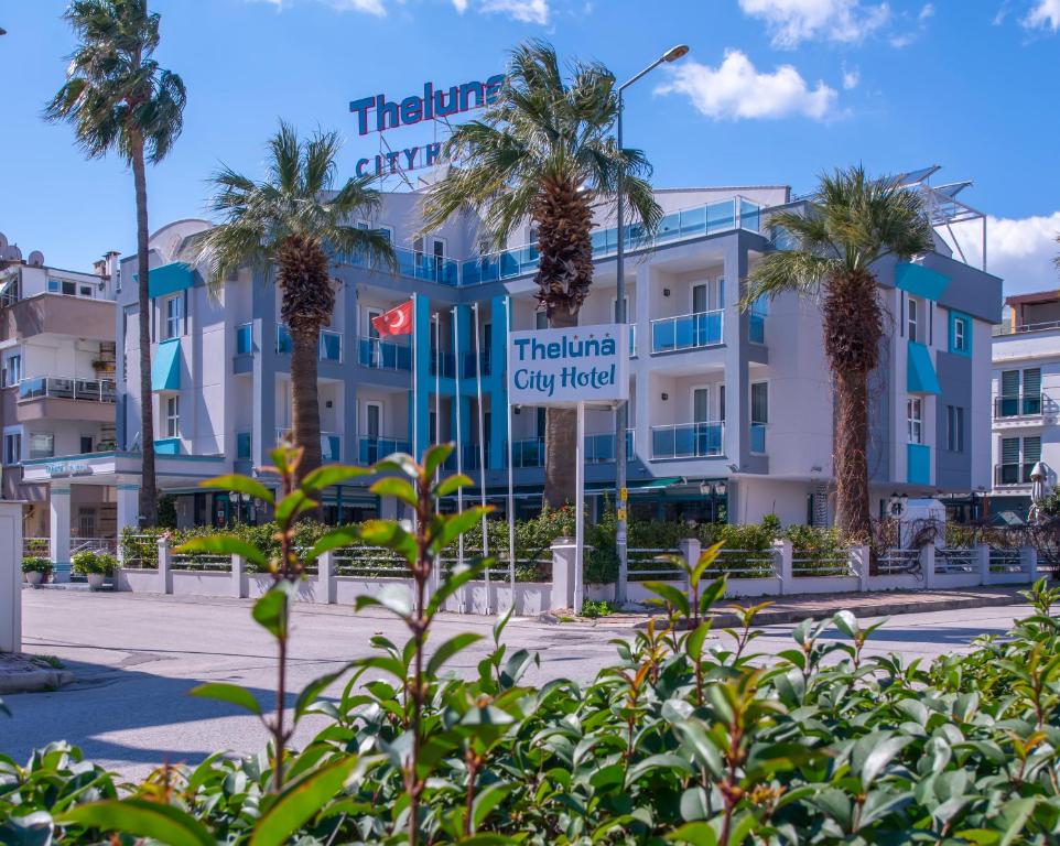 een gebouw met palmbomen ervoor bij Theluna City Hotel in Antalya