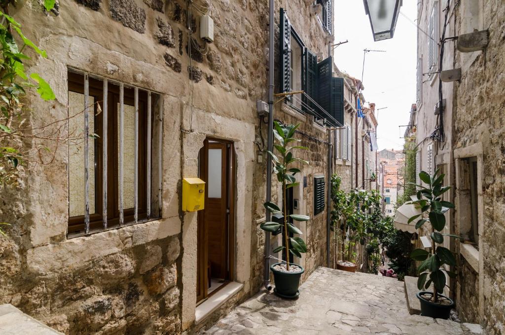 Une allée dans une vieille ville avec des plantes en pot dans l'établissement Apartment Ronchi, à Dubrovnik