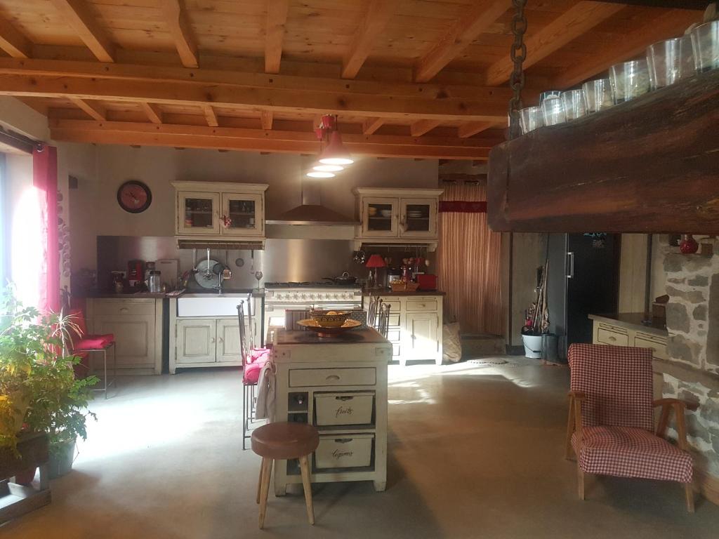 a kitchen with white cabinets and a table and chairs at Villa Misanid écrin de verdure à 15mm de la cité de Carcassonne in Mas-des-Cours