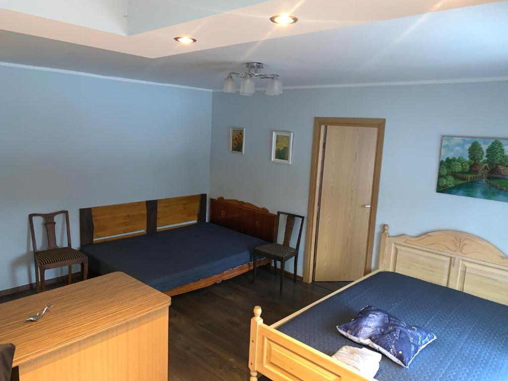 a bedroom with two beds and a table and chairs at Aardla - Nice 2-bedroom Apartment - Rahu street - 3 big beds in Tartu