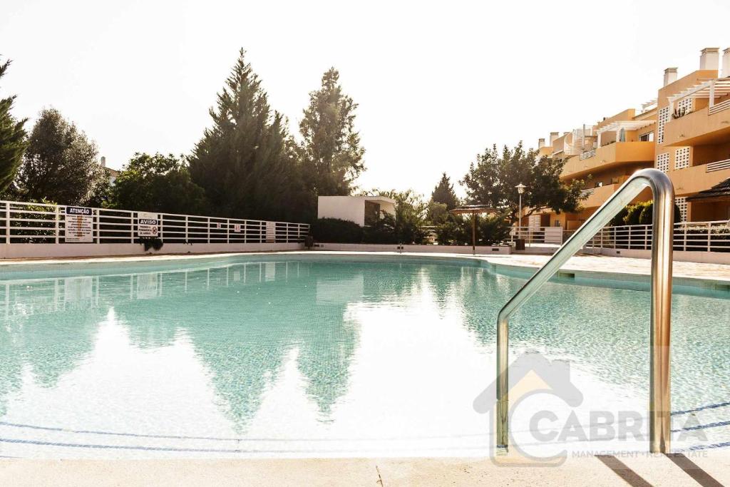 a swimming pool with blue water in a building at Apartamento Margarida Royal Cabanas Golf By Your Home Algarve in Tavira