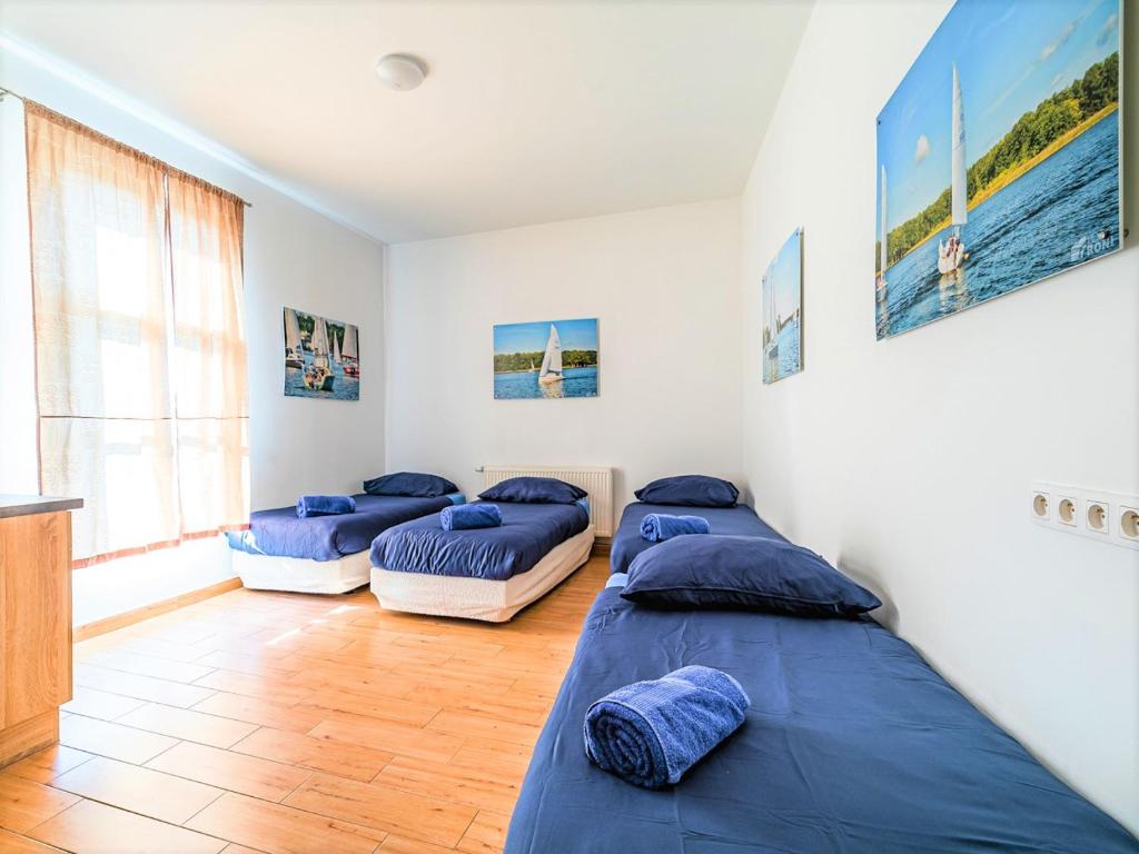 2 łóżka w pokoju z niebieskimi poduszkami w obiekcie SSW Grand Hostel Iława w Iławie