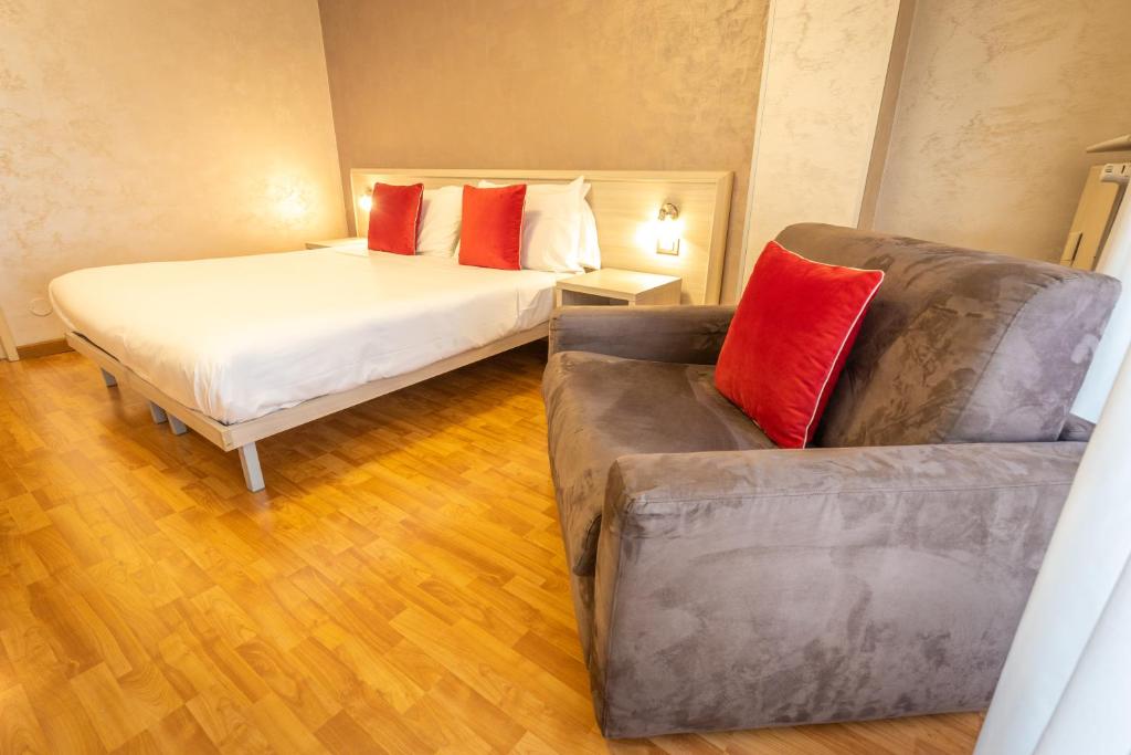 a bedroom with a bed and a couch in it at Hotel Lis in Asti