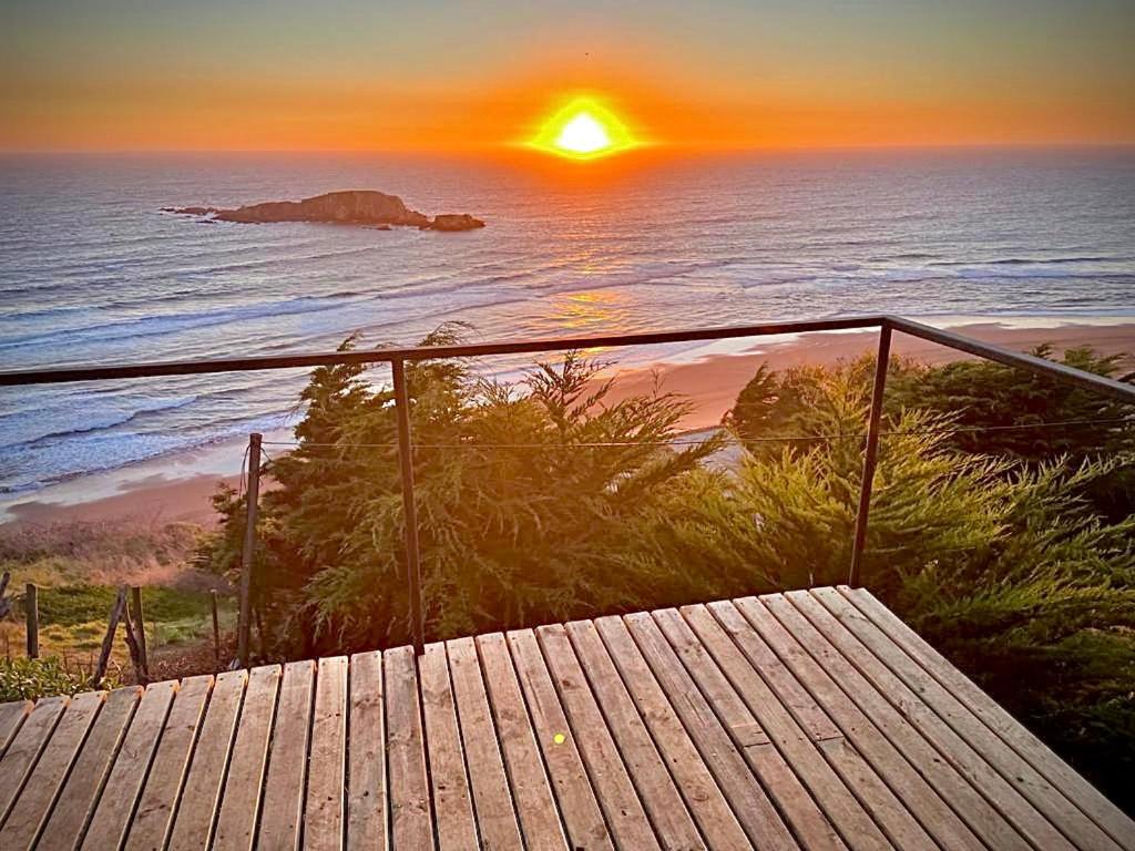 a sunset over the ocean from a wooden deck at Almar de Matanzas Tiny in Boca Pupuya